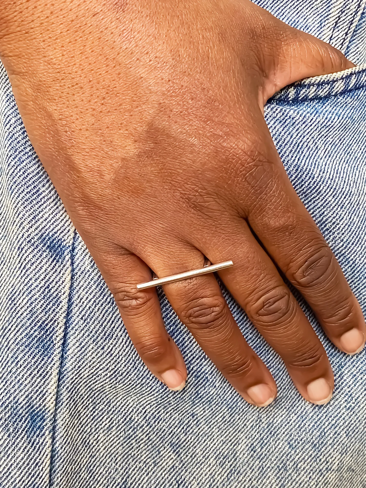Hand wearing the Sculpted Bar Ring in sterling silver on index finger.