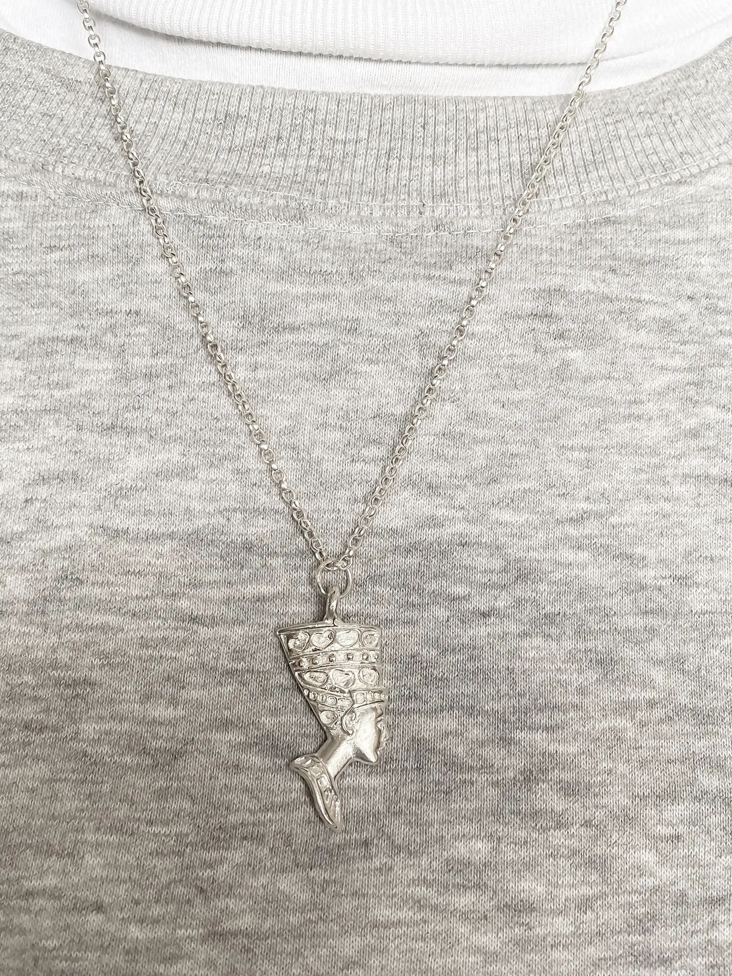 Nefertiti face necklace in sterling silver worn over a grey jumper