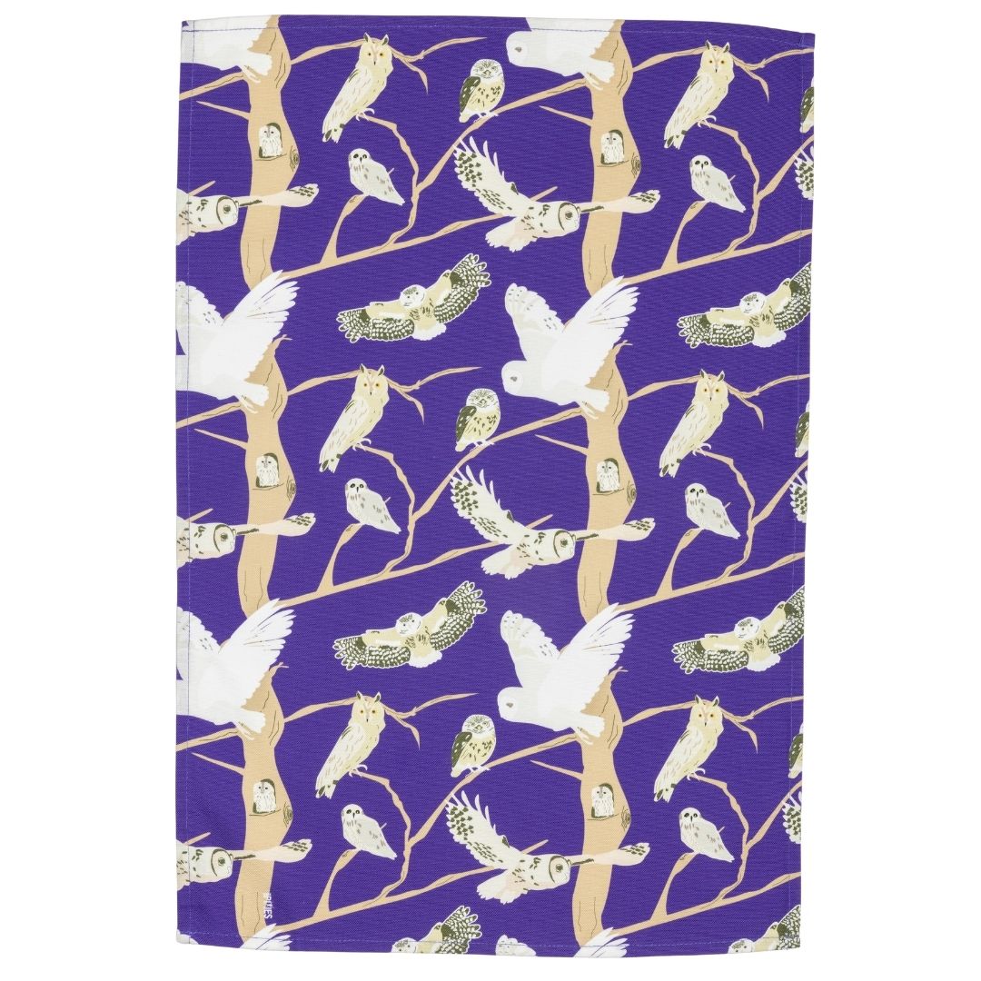 purple cotton kitchen cloth with owl illustrations shown laid out flat on a white background