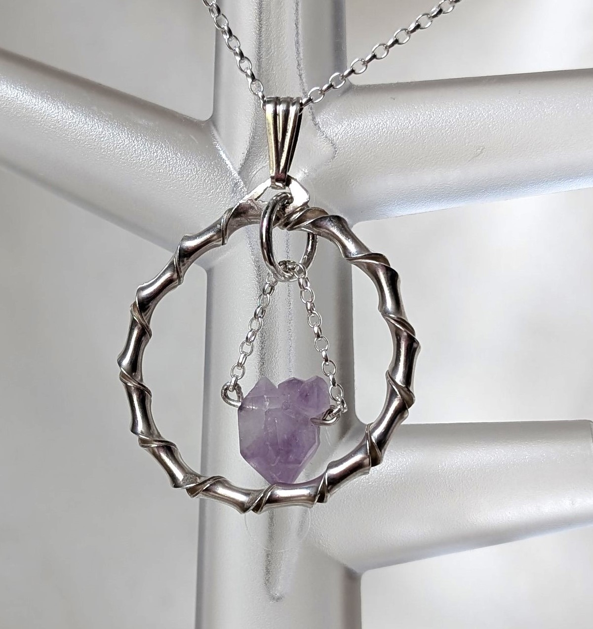 Amethyst in circular silver pendant