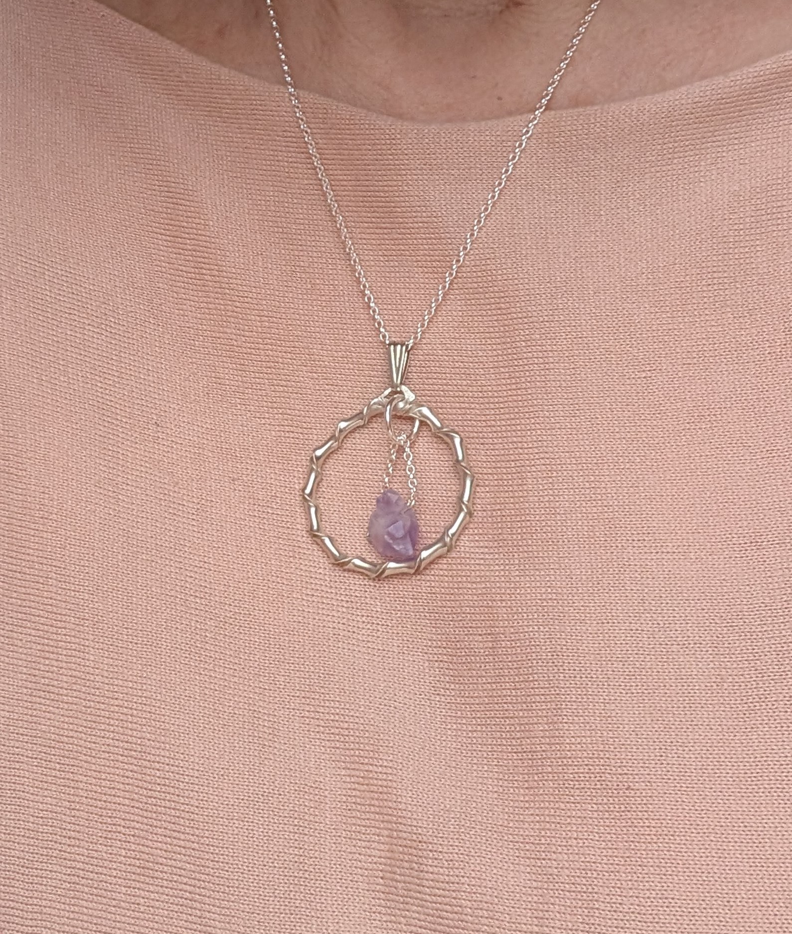 Amethyst in circular silver pendant