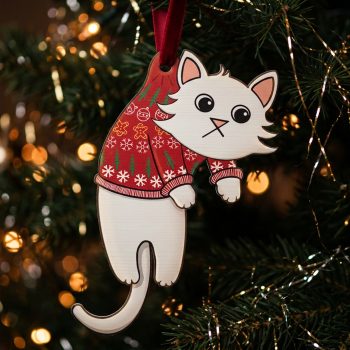 White fluffy cat wooden Christmas decoration wearing a red knitted jumper with snowflakes, hanging from a red ribbon